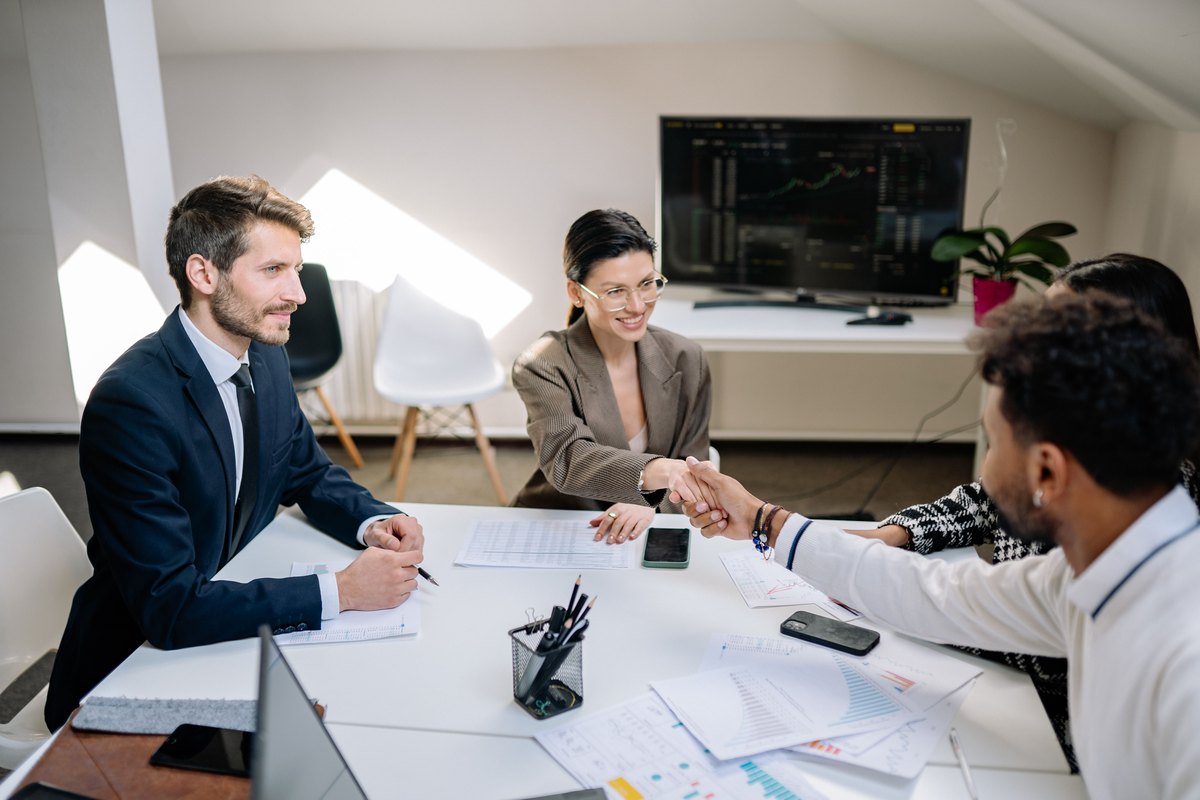 Partners meeting and shaking hands across a conference table