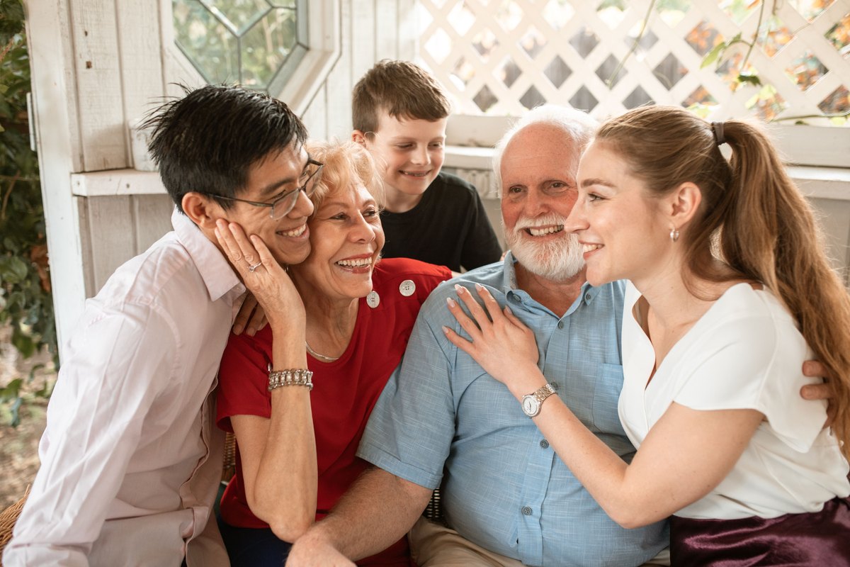 Three generations of a family laughing together on a porch